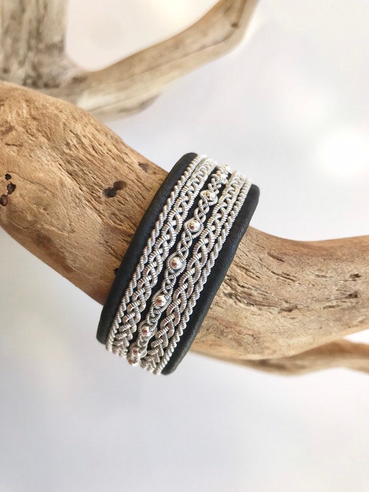 Wide black Scandinavian reindeer leather bracelets, with traditional pewter braiding, sterling silver beads and twisted borders.