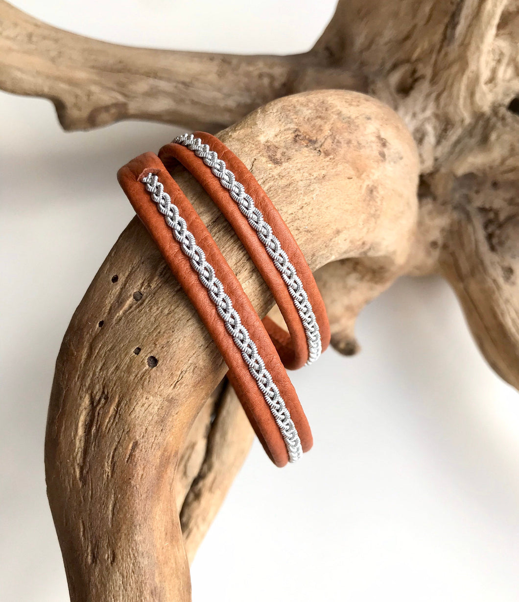 Traditional Sami reindeer leather bracelets, in tan with a braid of flat pewter threads.