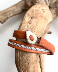 Traditional Sami reindeer leather bracelets, in tan with a braid of flat pewter threads.